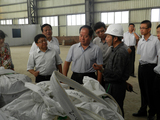 硕丰公司总经理张海应（右二）向自治区环保厅厅长安国通（左三）讲解工艺流程、产能并抽检合格产品